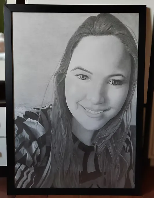 Retrato a grafite de uma mulher sorrindo, emoldurado